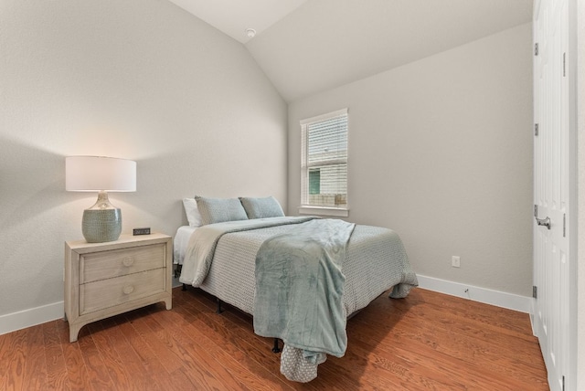 bedroom featuring vaulted ceiling, wood finished floors, and baseboards