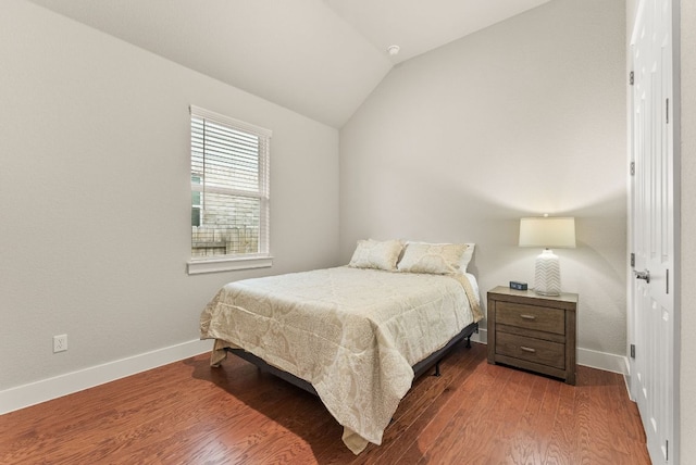 bedroom featuring lofted ceiling, wood finished floors, and baseboards