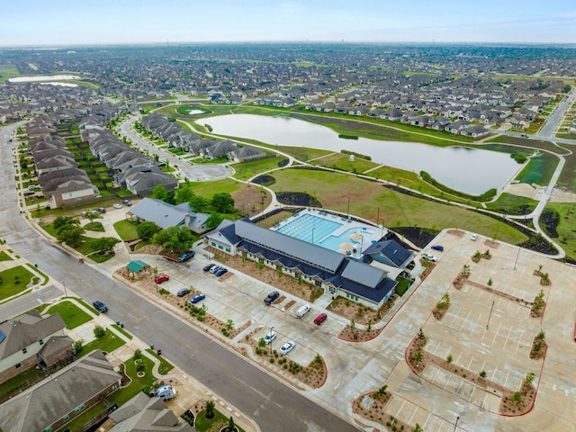aerial view of property's location featuring a large body of water and nearby suburban area