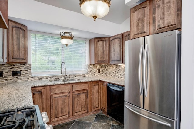 4703 Quicksilver Blvd, Austin, TX 78744 - kitchen featuring freestanding refrigerator, dishwasher, decorative backsplash, and brown cabinetry
