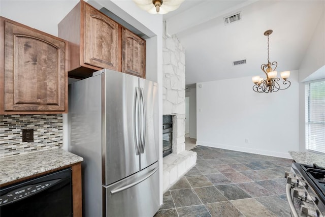 4703 Quicksilver Blvd, Austin, TX 78744 - kitchen featuring stainless steel appliances, decorative backsplash, a chandelier, dark stone finish flooring, and pendant lighting