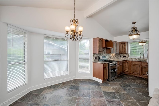 4703 Quicksilver Blvd, Austin, TX 78744 - kitchen with range with two ovens, stone tile floors, a chandelier, pendant lighting, and brown cabinetry