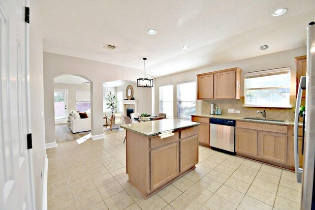 11120 Old Quarry Rd, Austin, TX 78717 - kitchen with dishwasher, arched walkways, a sink, a fireplace, and light tile patterned floors