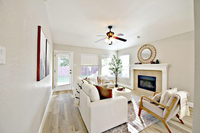 11120 Old Quarry Rd, Austin, TX 78717 - living room with baseboards, light wood-style floors, healthy amount of natural light, and a tiled fireplace