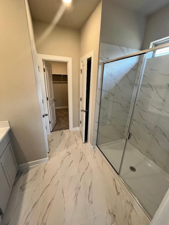 264 Little Green Trl, Jarrell, TX 76537 - bathroom featuring a marble finish shower, vanity, a walk in closet, and marble look tiles