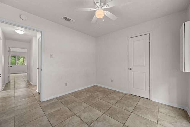 spare room with light tile patterned floors, ceiling fan, baseboards, and a smoke detector