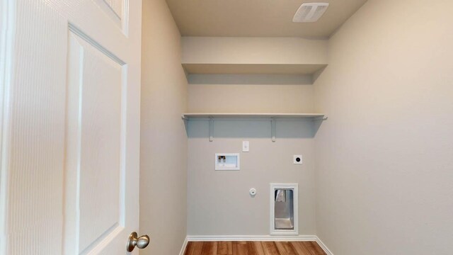 2402 Bee Creek Dr, Copperas Cove, TX 76522 - laundry area featuring electric dryer hookup, gas dryer hookup, hookup for a washing machine, wood finished floors, and baseboards