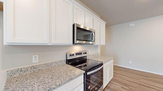 2402 Bee Creek Dr, Copperas Cove, TX 76522 - kitchen featuring stainless steel appliances, light wood-type flooring, white cabinets, baseboards, and light stone countertops