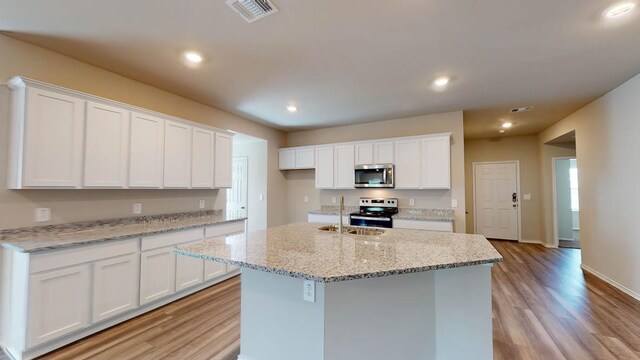 2402 Bee Creek Dr, Copperas Cove, TX 76522 - kitchen with appliances with stainless steel finishes, a sink, light wood-style floors, white cabinetry, and recessed lighting