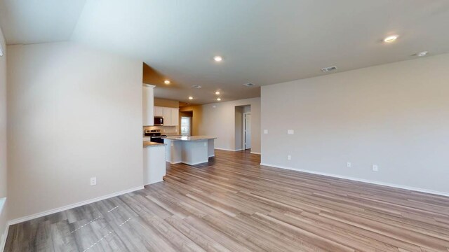 2402 Bee Creek Dr, Copperas Cove, TX 76522 - unfurnished living room featuring light wood-type flooring, baseboards, and recessed lighting