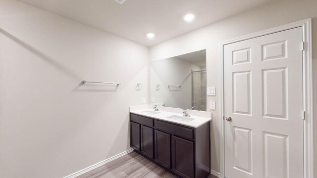 2402 Bee Creek Dr, Copperas Cove, TX 76522 - full bathroom featuring wood finished floors, double vanity, a shower with shower door, baseboards, and recessed lighting