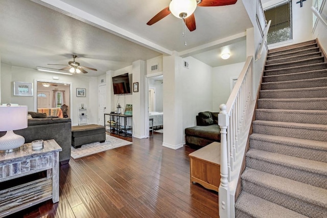 living room with a ceiling fan, stairs, dark wood-style flooring, and baseboards