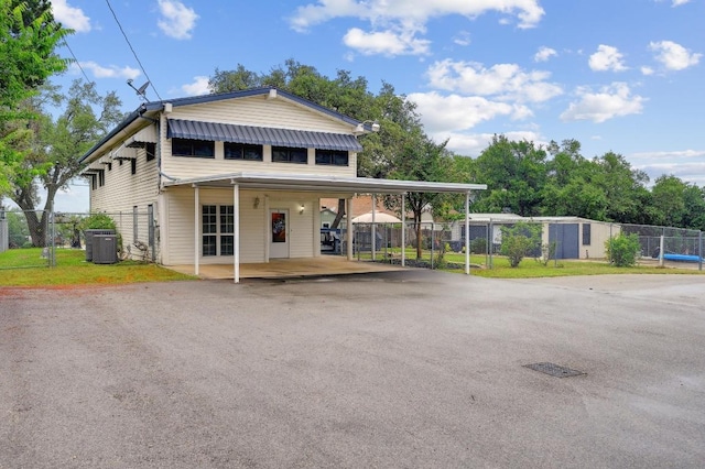 1303 Canyon Edge, Canyon Lake, TX 78133 - rear view of property featuring asphalt driveway, central air condition unit, a gate, and a carport