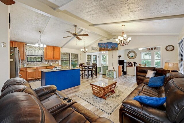 1303 Canyon Edge, Canyon Lake, TX 78133 - living room with a chandelier, a ceiling fan, healthy amount of natural light, light wood finished floors, and a textured ceiling