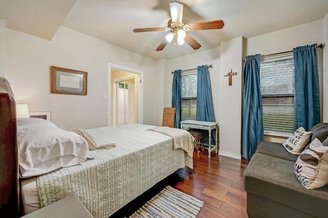 bedroom with dark wood-type flooring, multiple windows, baseboards, and ceiling fan