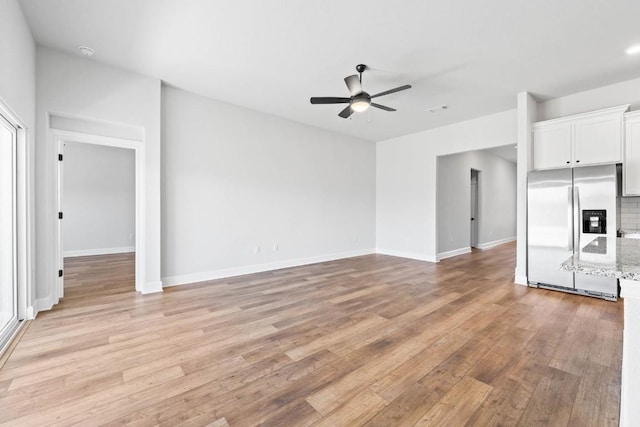 9321 Gladsome Path, Manor, TX 78653 - unfurnished living room featuring a ceiling fan, light wood-type flooring, and baseboards