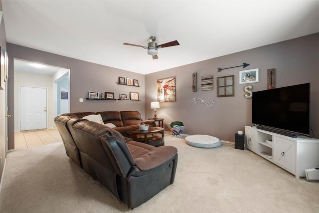 living area with light carpet, a ceiling fan, and baseboards
