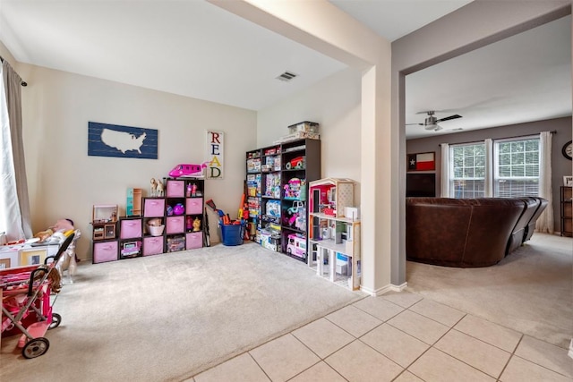 recreation room featuring carpet flooring, a ceiling fan, and tile patterned floors