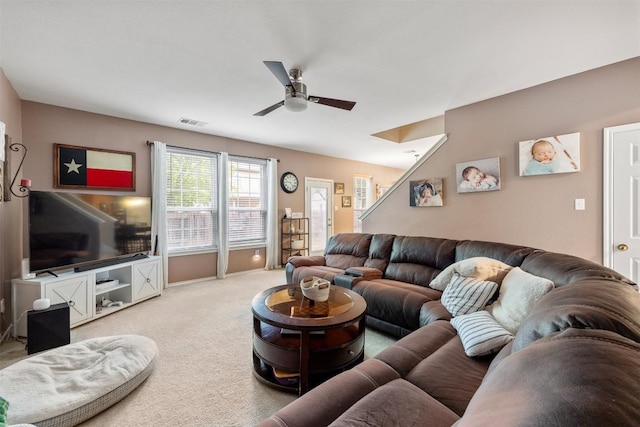 carpeted living area with ceiling fan