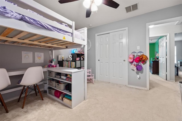 bedroom featuring light colored carpet, a closet, a ceiling fan, and baseboards