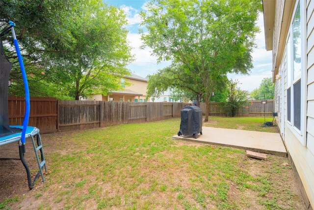 view of yard featuring a trampoline and a patio area