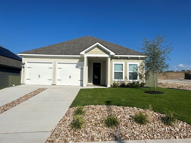 9701 Gladsome Path, Manor, TX 78653 - single story home with concrete driveway, an attached garage, a front yard, and roof with shingles