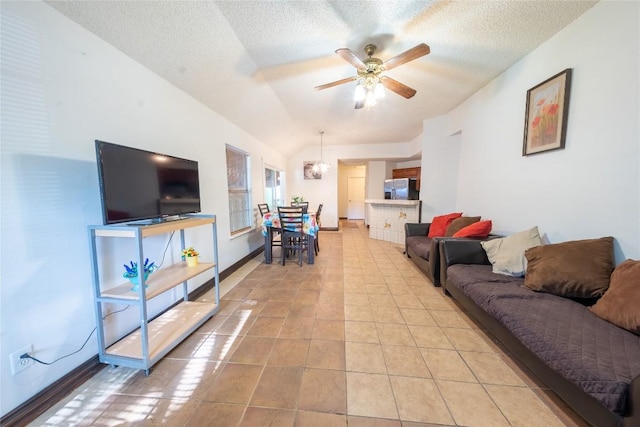 living room featuring a textured ceiling, light tile patterned floors, ceiling fan, and baseboards