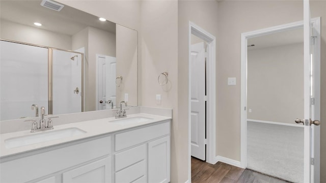 204 Inks Ln, Kyle, TX 78640 - full bath with wood finished floors, a shower stall, double vanity, baseboards, and recessed lighting