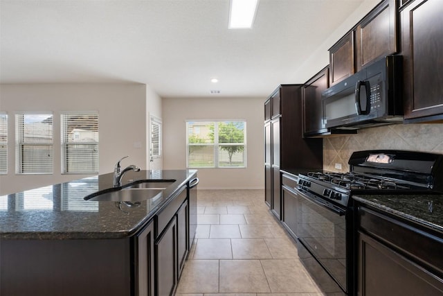 3548 Pauling Loop, Round Rock, TX 78665 - kitchen with black appliances, dark stone counters, tasteful backsplash, dark brown cabinetry, and an island with sink