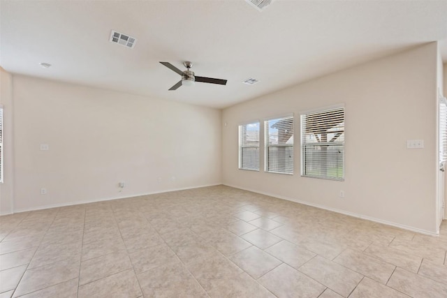 unfurnished room with light tile patterned flooring, a ceiling fan, and baseboards