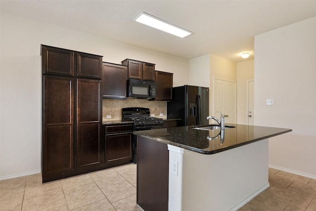 kitchen with black appliances, a sink, backsplash, a kitchen island with sink, and baseboards