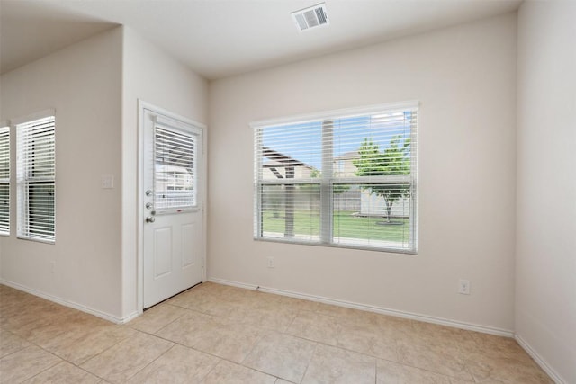foyer entrance with light tile patterned floors and baseboards