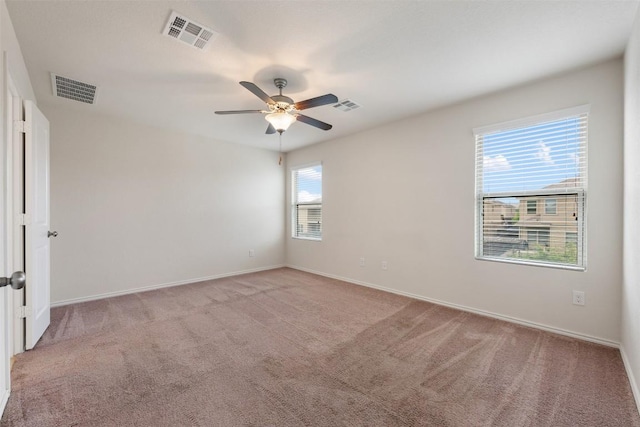 empty room featuring light carpet, ceiling fan, and baseboards