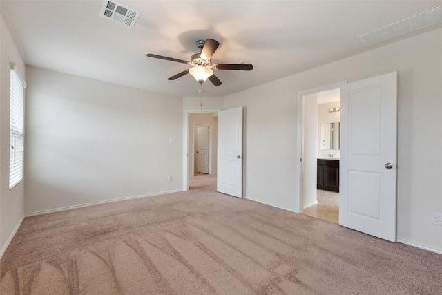 unfurnished bedroom featuring light carpet, multiple windows, baseboards, and a ceiling fan