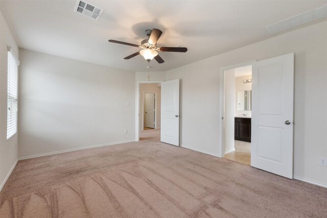 3548 Pauling Loop, Round Rock, TX 78665 - unfurnished bedroom with light colored carpet, multiple windows, a ceiling fan, and ensuite bath