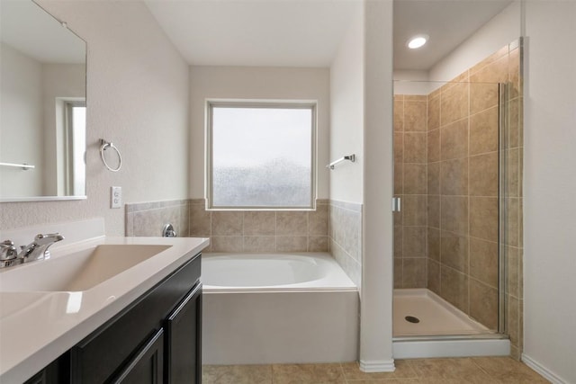 bathroom with a shower stall, tile patterned flooring, a garden tub, and vanity