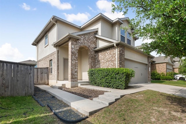 view of front of home featuring stucco siding, a garage, driveway, and fence