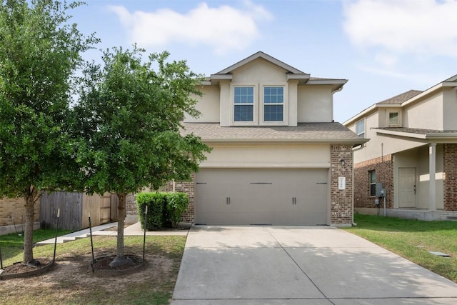 view of front facade featuring concrete driveway, an attached garage, fence, stucco siding, and brick siding