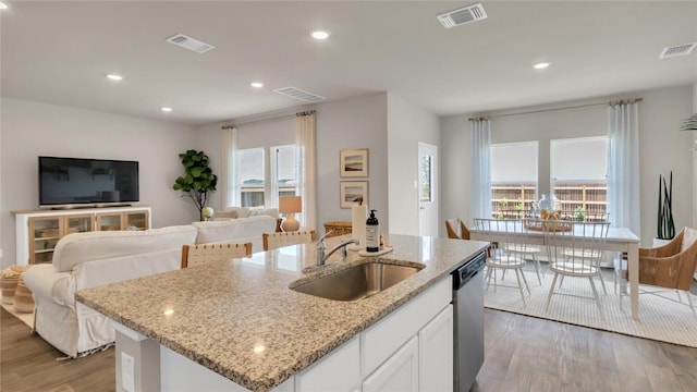154 Sandringham Loop, Uhland, TX 78640 - kitchen featuring a sink, light wood-style floors, stainless steel dishwasher, open floor plan, and recessed lighting