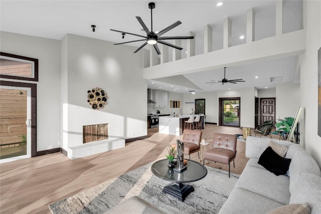 112 Paragon Ct, Lakeway, TX 78734 - living room featuring ceiling fan, light wood-type flooring, a high ceiling, recessed lighting, and baseboards