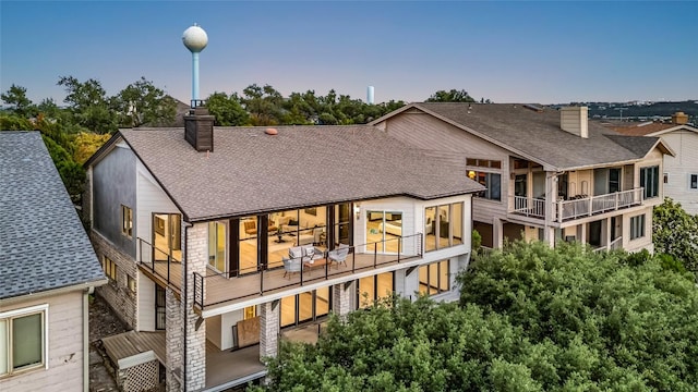 112 Paragon Ct, Lakeway, TX 78734 - back of house with a chimney, a shingled roof, and a balcony