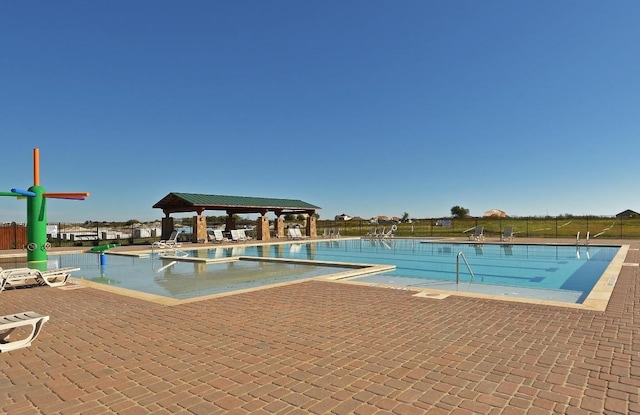 community pool with a gazebo, a patio, and fence