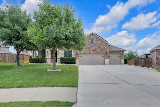 view of property hidden behind natural elements featuring concrete driveway, an attached garage, and brick siding