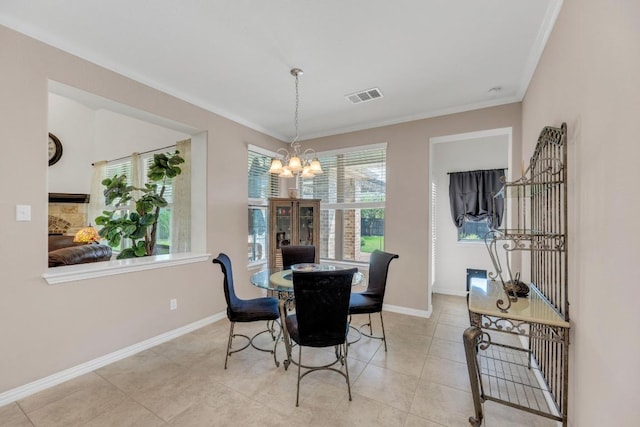 tiled dining area with a chandelier, baseboards, and crown molding