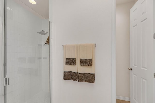 full bathroom featuring a shower stall and baseboards