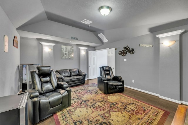 living area featuring vaulted ceiling, wood finished floors, and baseboards