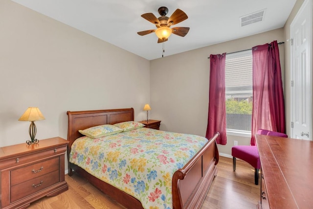 bedroom with light wood-type flooring, baseboards, and a ceiling fan