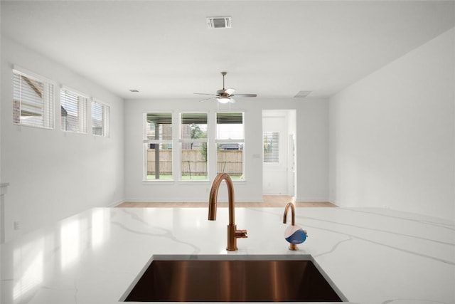 204 Ridgewell Loop, Georgetown, TX 78633 - kitchen with a sink, light stone counters, ceiling fan, and open floor plan