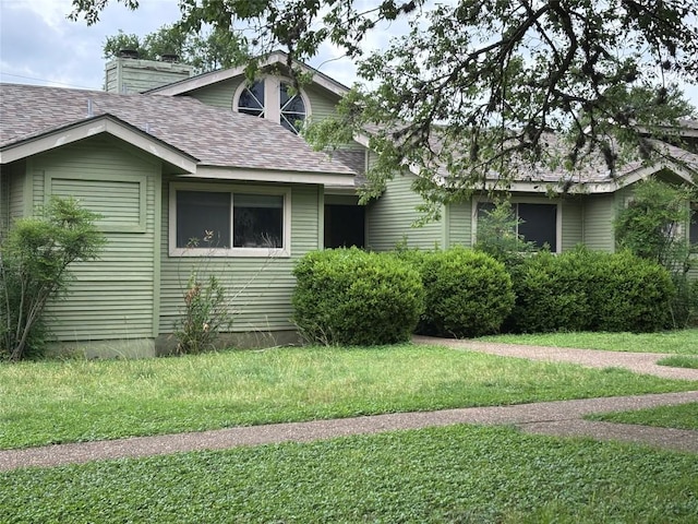 1404 Andra Ln, San Marcos, TX 78666 - view of front of house with a shingled roof, a front yard, and a chimney