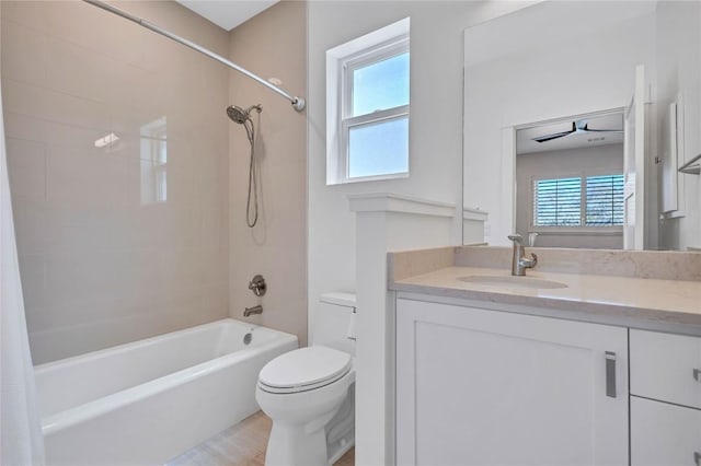bathroom with healthy amount of natural light, toilet, vanity, and shower / bathtub combination